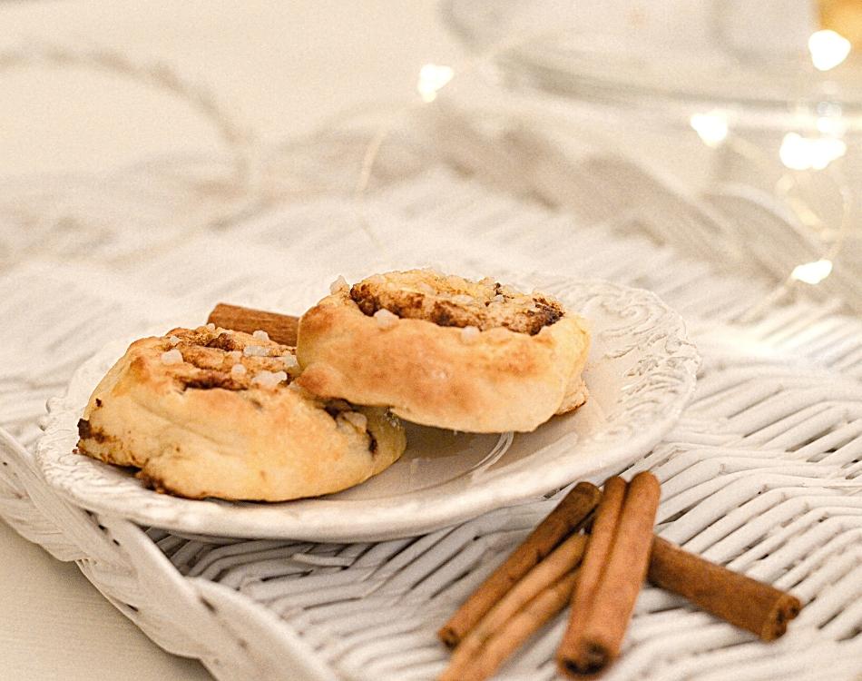 Duo de roulés à la cannelle sur une assiette blanche